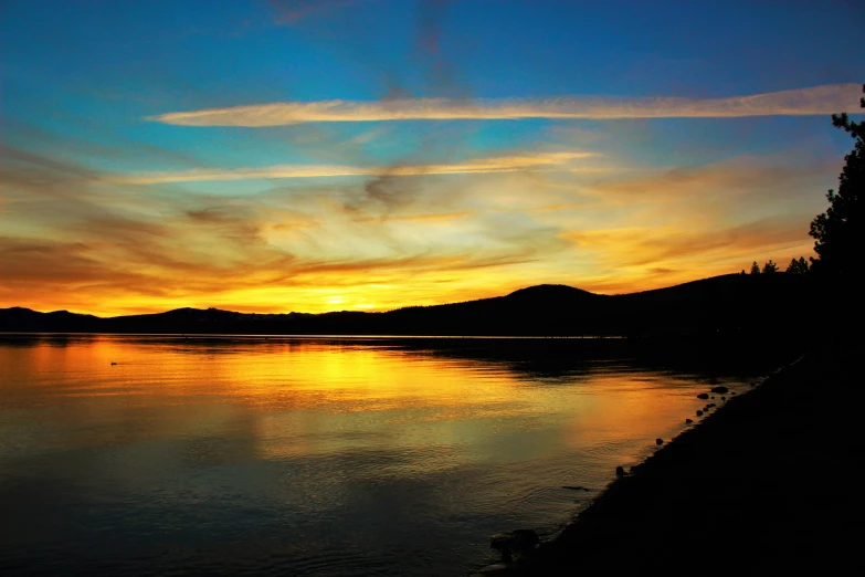 a large body of water with a sunset in the background, pexels contest winner, hudson river school, big bear lake california, shades of gold display naturally, where a large, a colorful