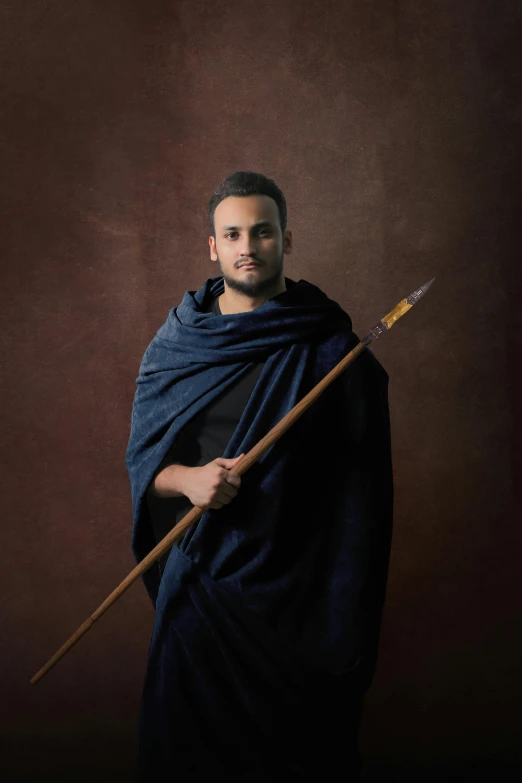 a man dressed in medieval clothing holding a spear, a portrait, pexels contest winner, young greek man, middle eastern, studio potrait, wearing toga