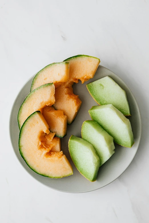 a white plate topped with slices of melon, heavily upvoted, organic shape, full product shot, peach