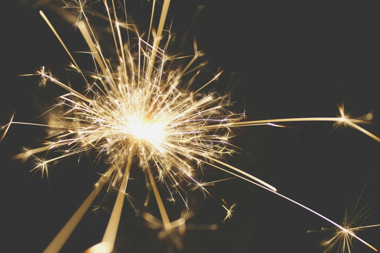 a close up of a sparkler on a black background, pexels, retro stylised, instagram post, shiny gold, magnesium