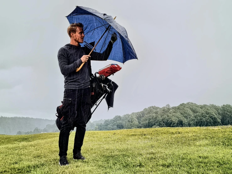 a man standing in a field holding an umbrella, wearing adventuring gear, profile image