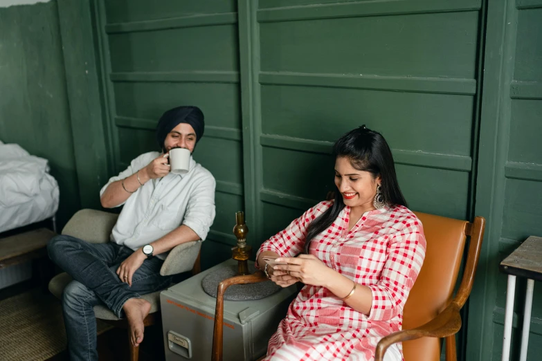 a man and a woman sitting next to each other, inspired by Manjit Bawa, trending on pexels, holding a drink, furniture around, 15081959 21121991 01012000 4k, high-quality photo