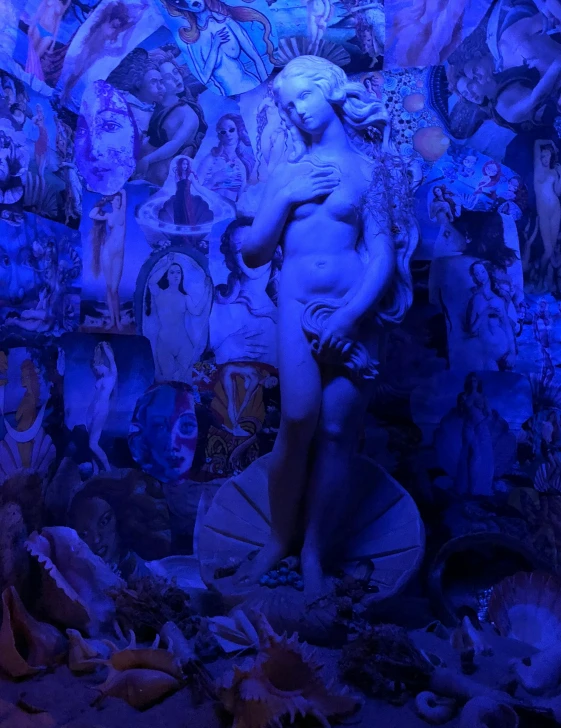 a man that is standing in front of a wall, a statue, inspired by David LaChapelle, mannerism, blue scales covering her chest, standing in a grotto, full of paintings of angels, black light