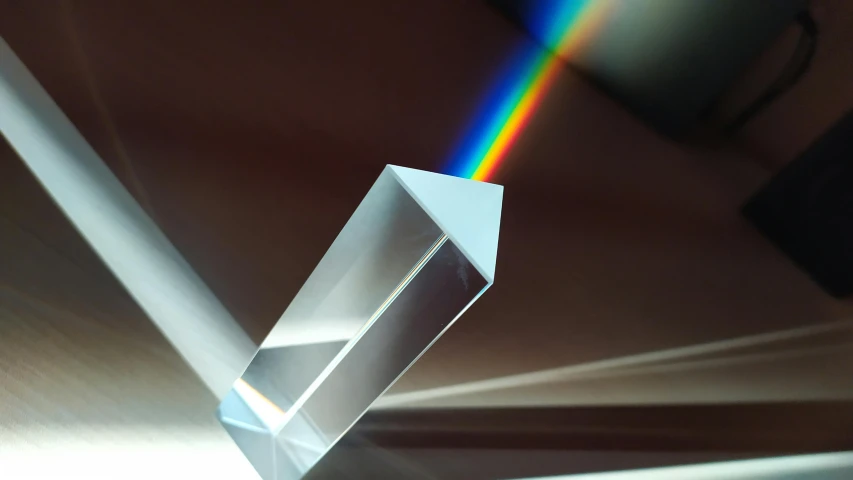 a close up of a glass object with a rainbow in the background, inspired by Gabriel Dawe, unsplash contest winner, holography, volumetric light and shadow, quartz crystal, miniature product photo, 3/4 view from below