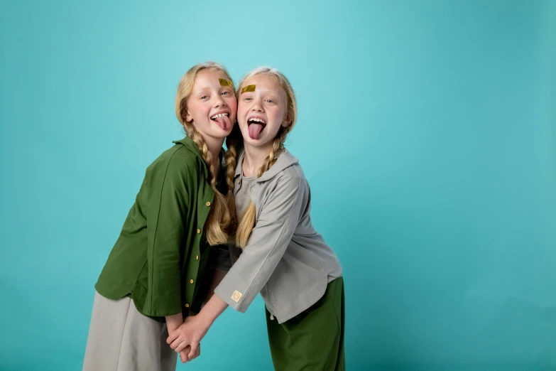 a couple of women standing next to each other, an album cover, inspired by Elsa Beskow, unsplash, head bent back in laughter, girl wearing uniform, studio shoot, live action children's tv show