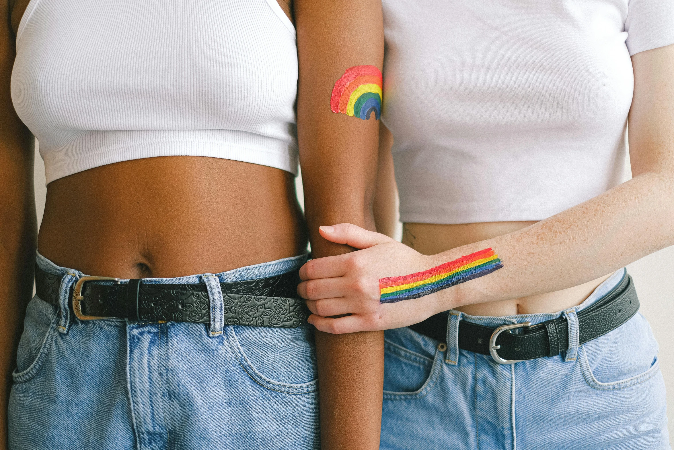 a couple of women standing next to each other, a tattoo, trending on pexels, rainbow accents, bandage on arms, diverse, stickers