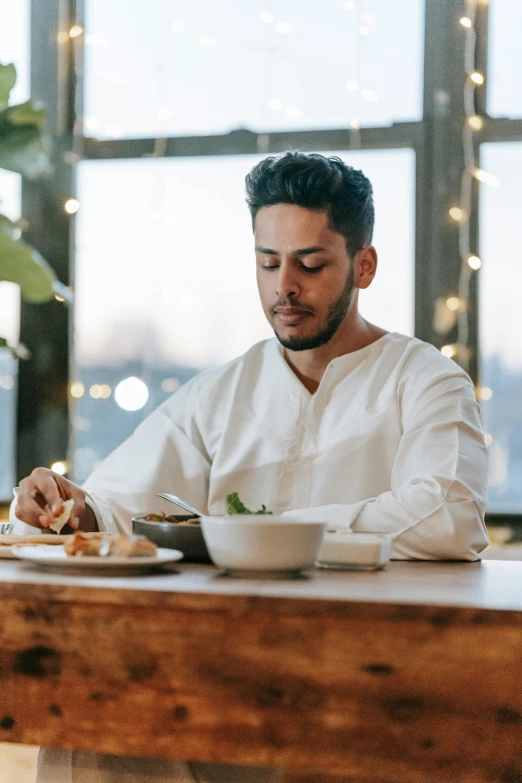 a man sitting at a table with a plate of food, profile image, middle eastern skin, 2019 trending photo, asian male