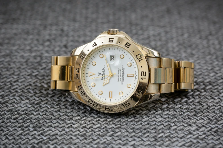 a close up of a watch on a table, a portrait, by Kev Walker, reddit, gold and white, rolex, on a gray background, explorer