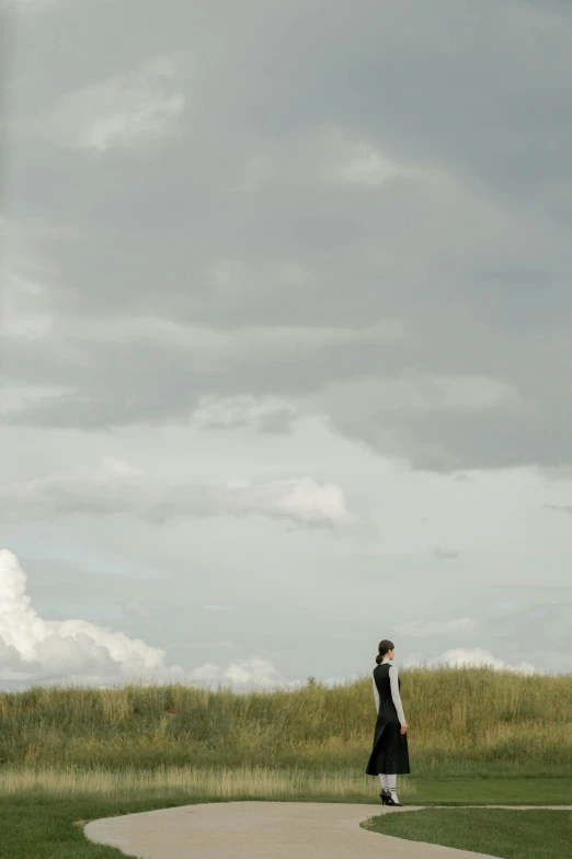 a woman flying a kite on top of a lush green field, inspired by Andrew Wyeth, unsplash, surrealism, nadav kander, jeremy lipking full length shot, [ cinematic, standing on a cloud