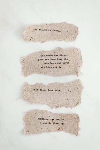 four pieces of paper with words written on them, inspired by Dorothy Burroughes, unsplash, made of clay, ashes, full body shot close up, detailed product shot