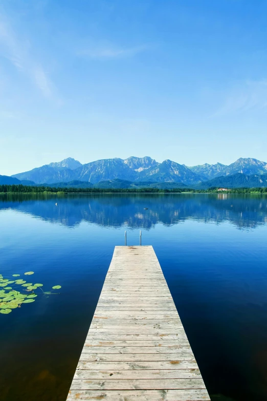 a dock on a lake with mountains in the background, by wolfgang lettl, ultrawide landscape, may