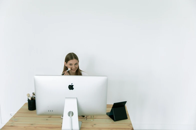 a woman sitting at a desk in front of a computer, unsplash, white bg, background image, ignant, some people are sitting