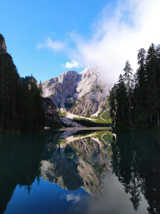 a body of water with a mountain in the background, in the dolomites, posing, very reflective, uploaded