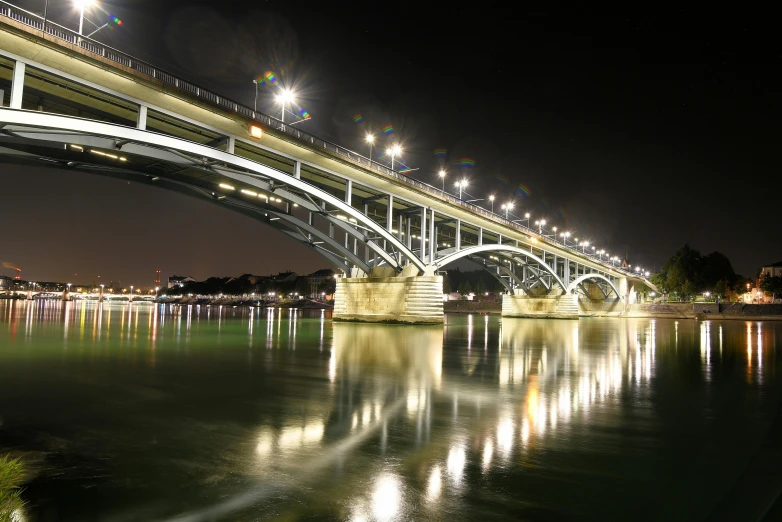 a bridge over a body of water at night, by Adam Szentpétery, pexels contest winner, art nouveau, jerez, olafur eliasson, thumbnail, indore