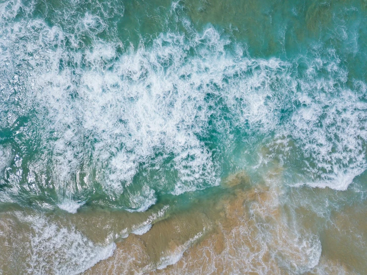 a person riding a surfboard on top of a sandy beach, pexels contest winner, renaissance, azure waves of water, looking down from above, glistening seafoam, mutiversal tsunami