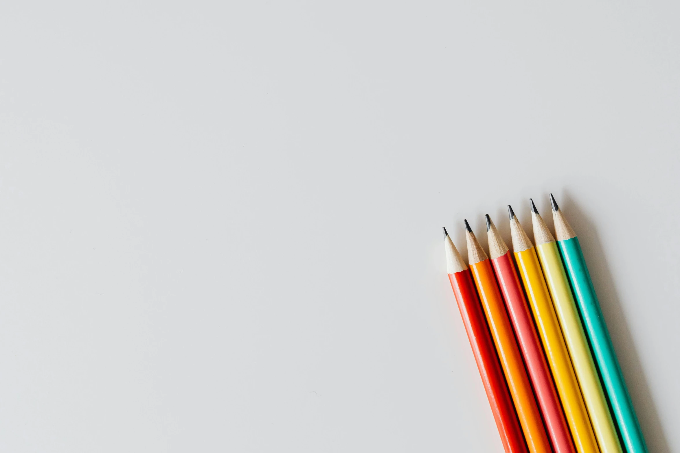 a group of colored pencils sitting on top of a white surface, by Carey Morris, trending on pexels, minimalism, red+yellow colours, penned with thin colors on white, on a gray background, multiple stories