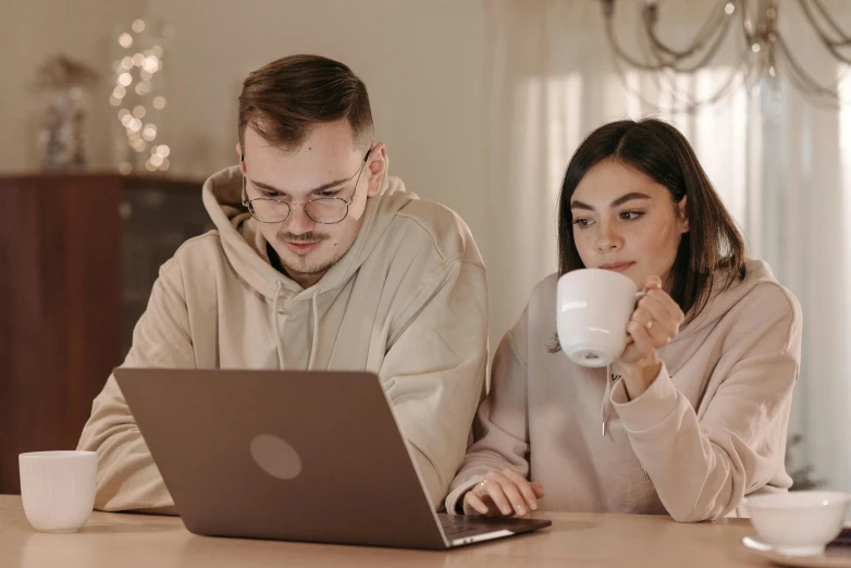 a man and a woman sitting at a table with a laptop, trending on pexels, with a white mug, avatar image, pokimane, high quality image