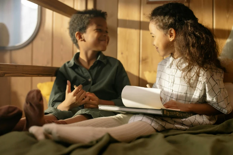 a couple of kids sitting on top of a bed, pexels contest winner, hurufiyya, reading the book about love, in a cabin, still image from tv series, brown