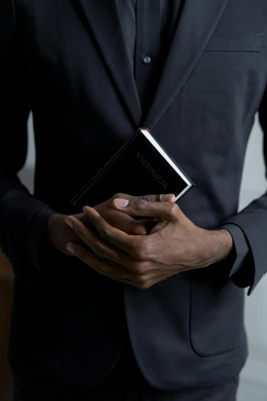 a man in a suit holding a bible, by Carey Morris, black main color, 15081959 21121991 01012000 4k, panel of black, pray