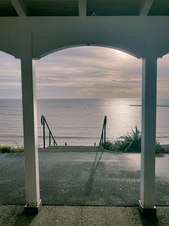 a view of the ocean from a covered porch, inspired by William Trost Richards, unsplash, todd hido, archway, slide show, multiple stories