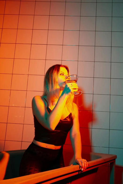 a woman in a black dress drinking from a glass, an album cover, inspired by Elsa Bleda, pexels, altermodern, neon basement, in a bathroom, profile image, people drinking beer