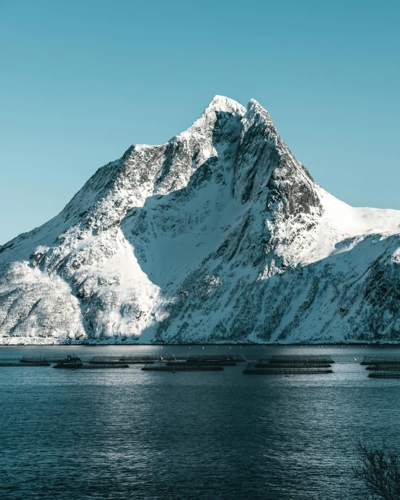 a large body of water with a mountain in the background, inspired by Johan Christian Dahl, pexels contest winner, snowy winter, exterior photo, multiple stories, stacked image