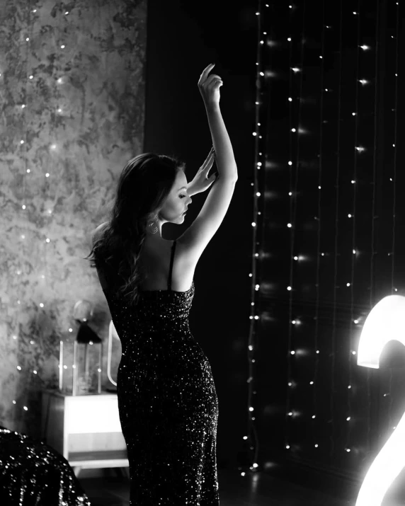 a black and white photo of a woman in a dress, by Dimitre Manassiev Mehandjiysky, unsplash, arabesque, flashing lights, pose(arms up + happy), nina dobrev, fashion shoot 8k