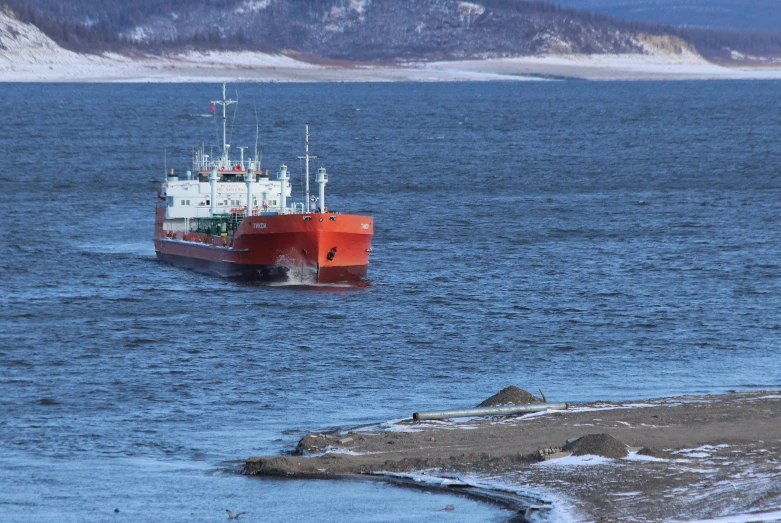 a red and white boat in a body of water, by Sven Erixson, pexels contest winner, neo norilsk, utilitarian cargo ship, grey, geology