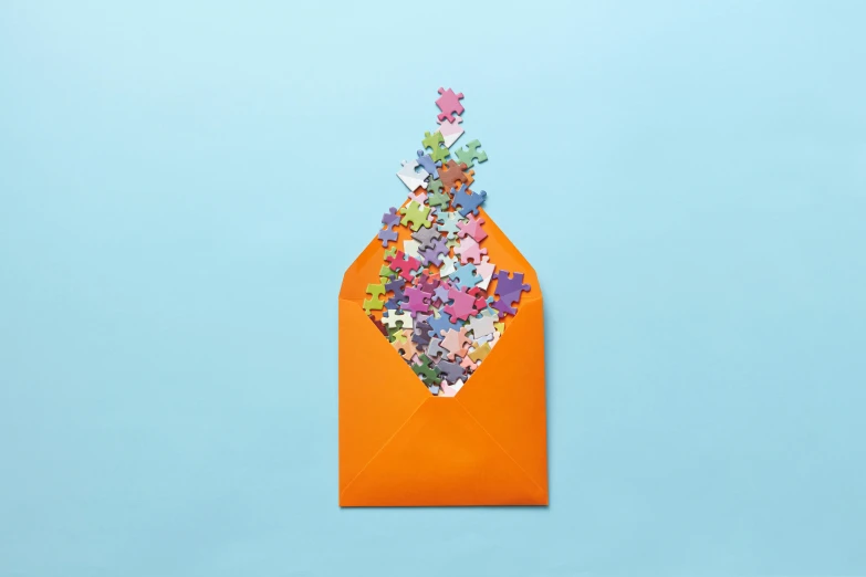 an orange envelope sitting on top of a blue surface, a jigsaw puzzle, by Joseph-Marie Vien, conceptual art, explosion of colorful flowers, ecommerce photograph, ffffound, fanart