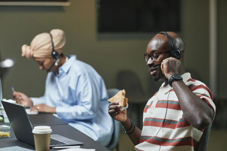 a man sitting at a table with a sandwich in front of him, inspired by Ismail Gulgee, trending on pexels, wearing headset, in an call centre office, lance reddick, african canadian