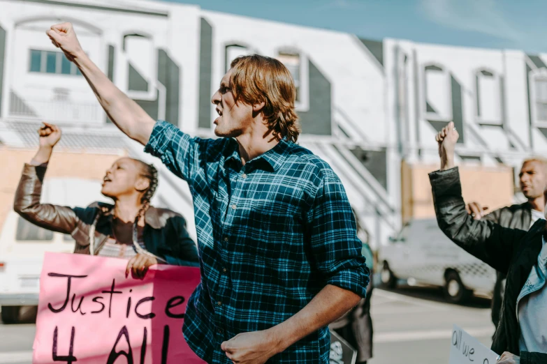 a group of people standing on the side of a road, trending on pexels, renaissance, protesters holding placards, handsome man, alana fletcher, raised hand