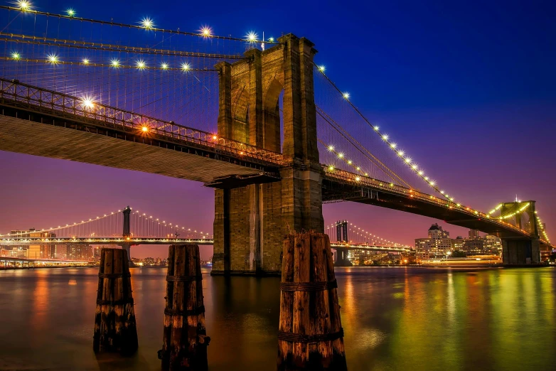 the brooklyn bridge is lit up at night, pexels contest winner, hudson river school, hyper - detailed color photo, 8k resolution”, dramatic ”, dramatic”