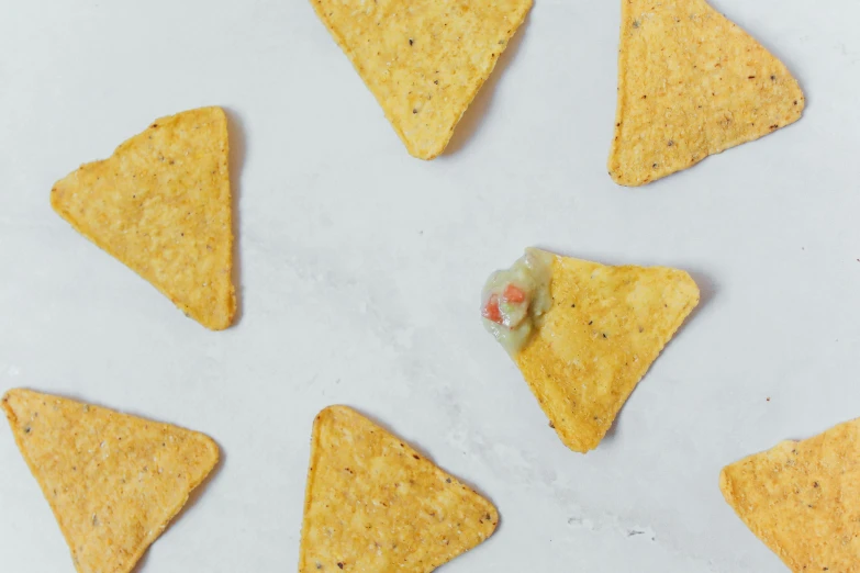 a white plate topped with tortilla chips, trending on pexels, surrealism, background image, pickle rick, terrazzo, grey