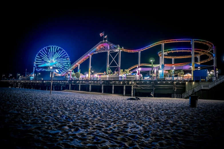 a roller coaster at night on the beach, a picture, by Meredith Dillman, unsplash contest winner, santa monica beach, avatar image, colored photo, ground level shot