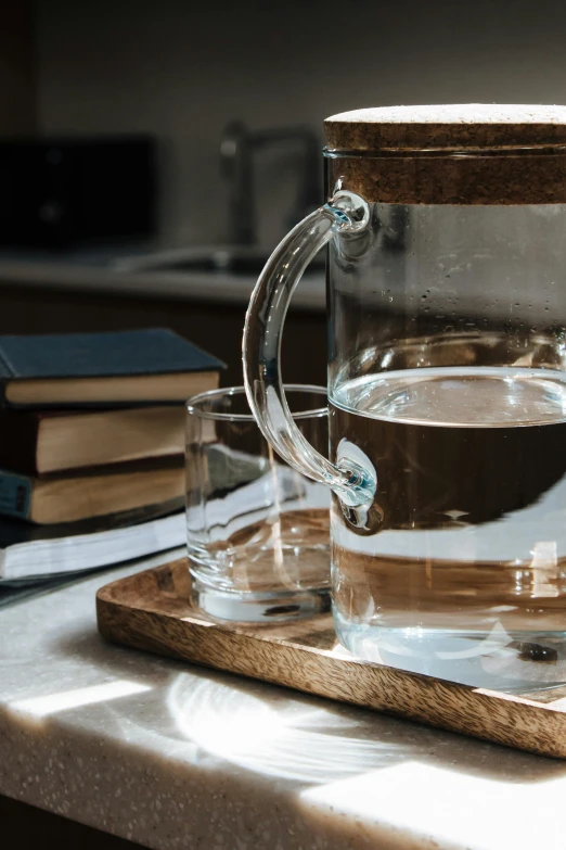 a cup of coffee sitting on top of a wooden tray, a still life, pexels, standing water, scientific glassware, books on side table, strong backlight