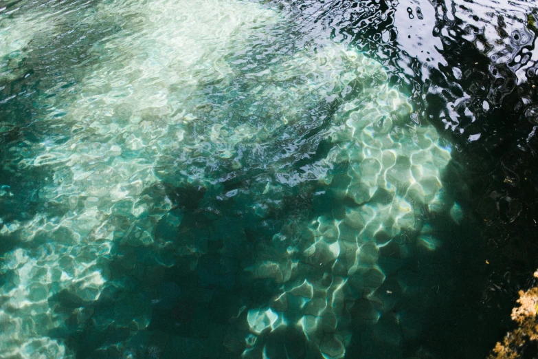 a person riding a surf board on top of a body of water, an album cover, inspired by Elsa Bleda, unsplash, hurufiyya, underwater crystals, dapped light, dark green water, ignant