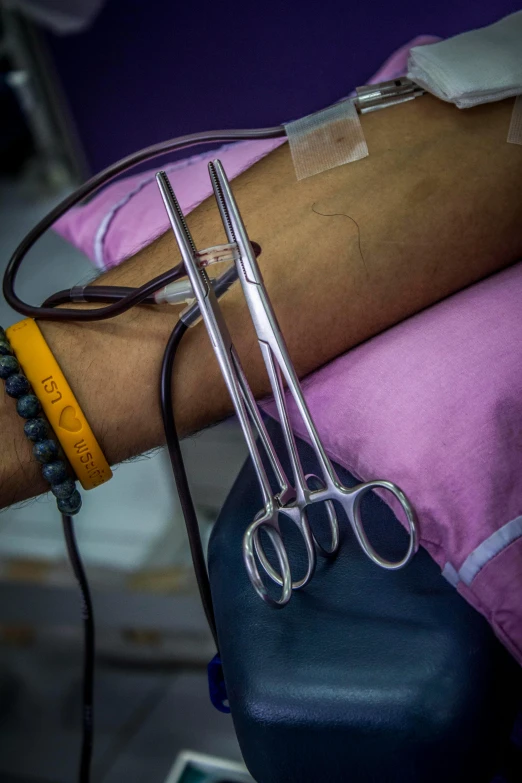 a close up of a person's arm with scissors on it, flickr, colorful medical equipment, multiple stories, india, contain