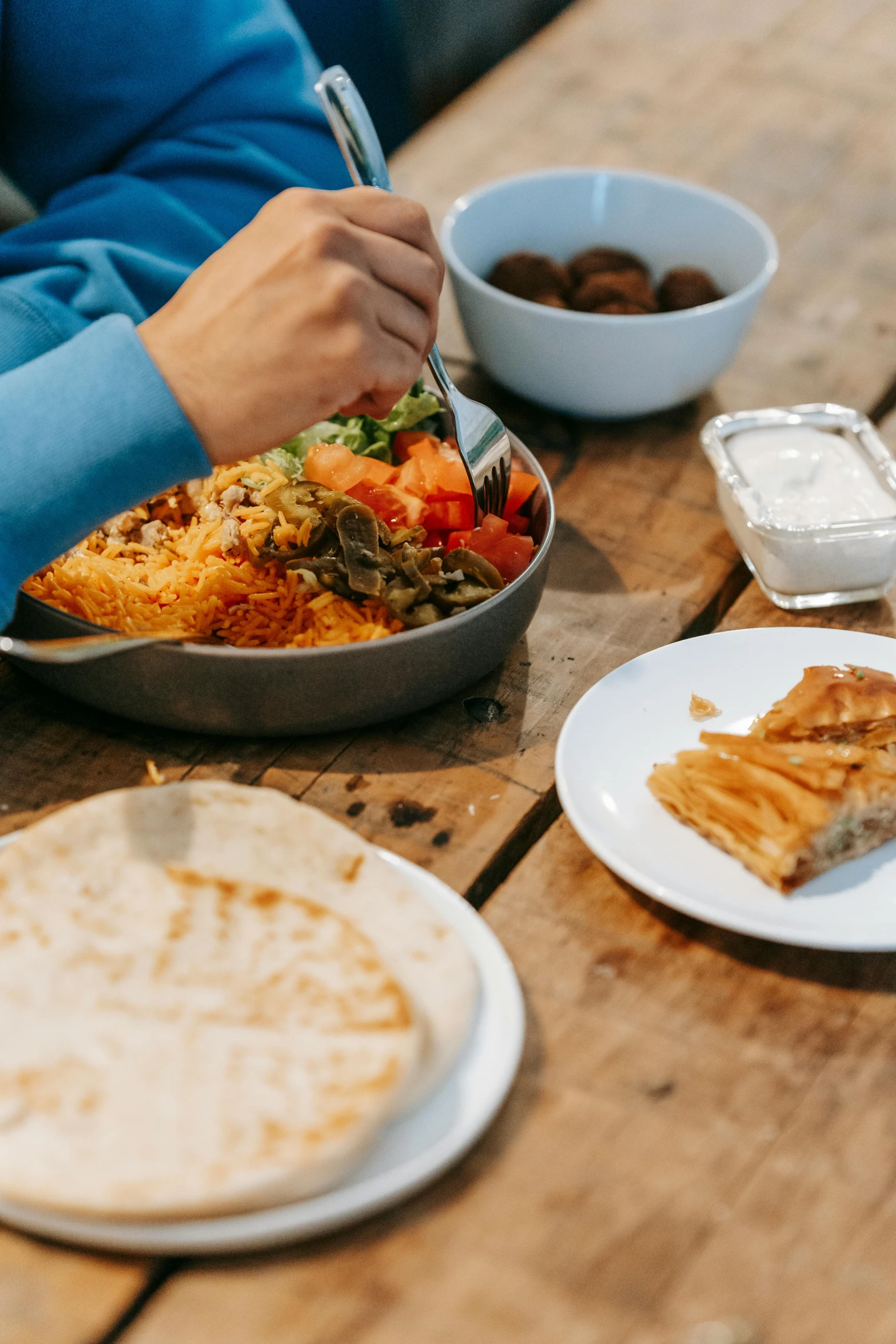 a person sitting at a table with plates of food, a picture, unsplash, dau-al-set, camping, oman, whistler, close-up photograph