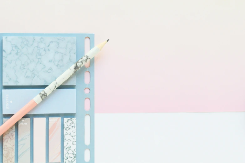 a pencil sitting on top of a piece of paper, inspired by Harvey Quaytman, trending on pexels, postminimalism, pink marble building, planner stickers, blue and white colour scheme, translucent pastel panels