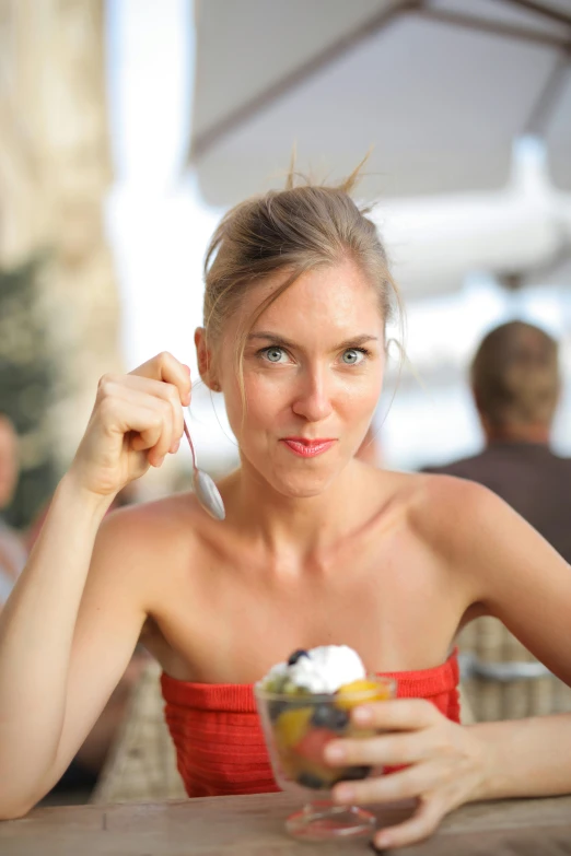 a woman sitting at a table eating an ice cream sundae, by Sven Erixson, unsplash, renaissance, good looking face, square, vacation, taken in the late 2010s