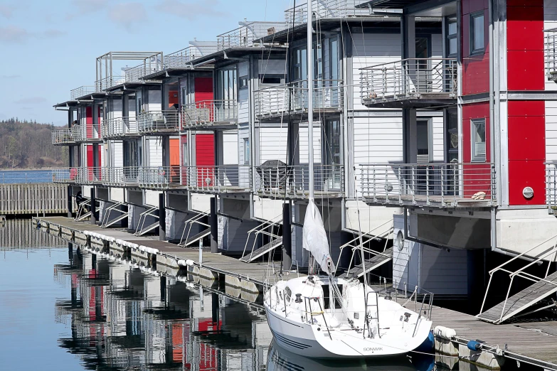 a white boat sitting on top of a body of water, a photo, inspired by Charles Rennie Mackintosh, modernism, houses on stilts, payne's grey and venetian red, melbourne, shipyard