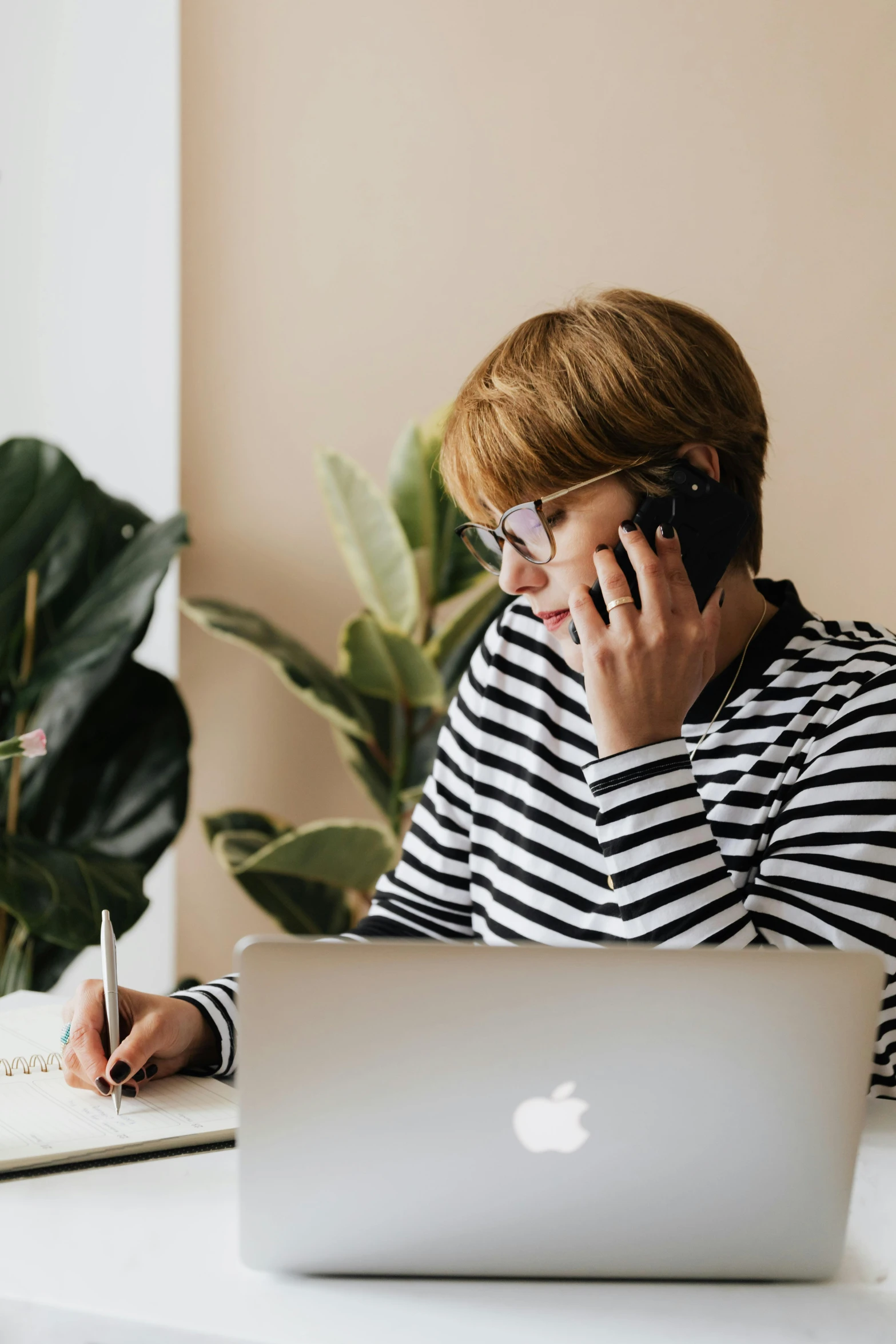 a woman sitting at a table talking on a cell phone, trending on pexels, using a macbook, wearing stripe shirt, it specialist, bold black lines