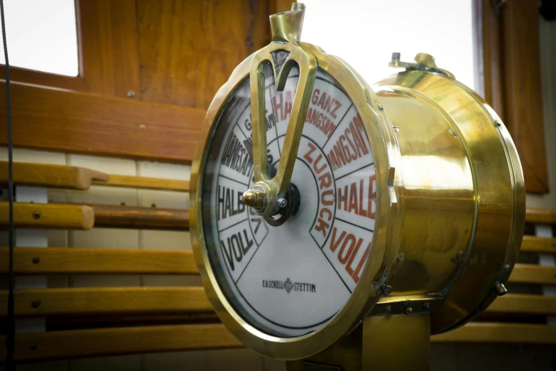 a clock sitting on top of a wooden bench, victorian fire ship, charts, close up photograph, shiny brass