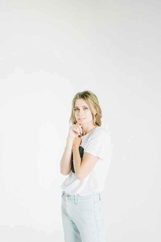 a woman standing in front of a white wall, by Sara Saftleven, trending on unsplash, happening, portrait of kim wexler, sitting with wrists together, music video, on clear background