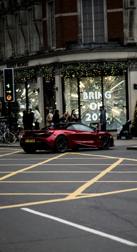 a red sports car driving down a city street, by Nick Fudge, pexels contest winner, excessivism, square, christmas, lotus, f12