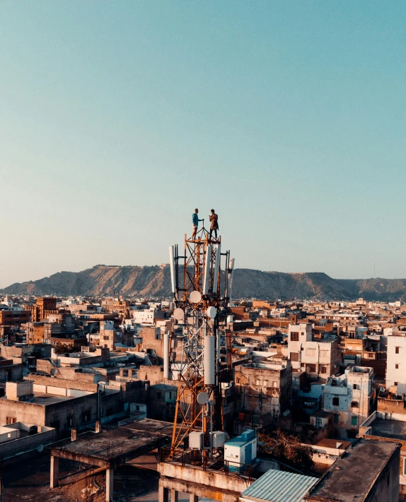 a tall tower sitting in the middle of a city, pexels contest winner, transmitters on roof, oman, trending on tiktok, rooftop romantic