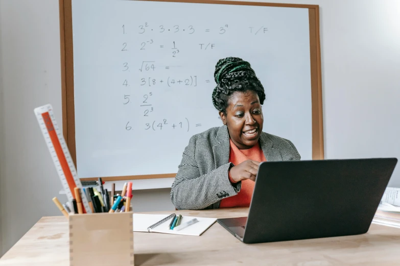 a woman sitting at a desk using a laptop computer, pexels contest winner, teacher, essence, math inspired, riyahd cassiem