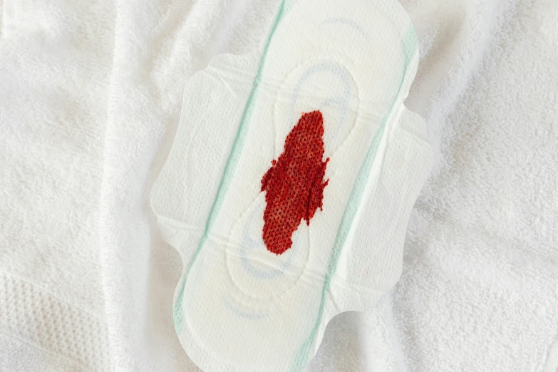 a white cloth with a red patch on it, contracept, bloody ocean, soft pads, detailed product image