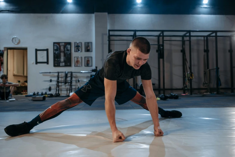 a man doing push ups in a gym, by Emma Andijewska, khabib, doing splits and stretching, full body hero, shot on sony a 7