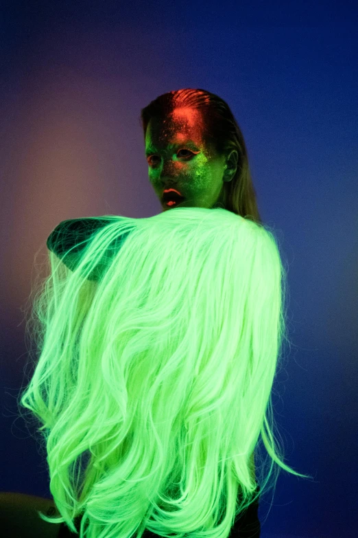 a woman with green hair standing in front of a blue background, inspired by Elsa Bleda, conceptual art, neon radioactive swamp, slide show, long glowing hair, bodypaint
